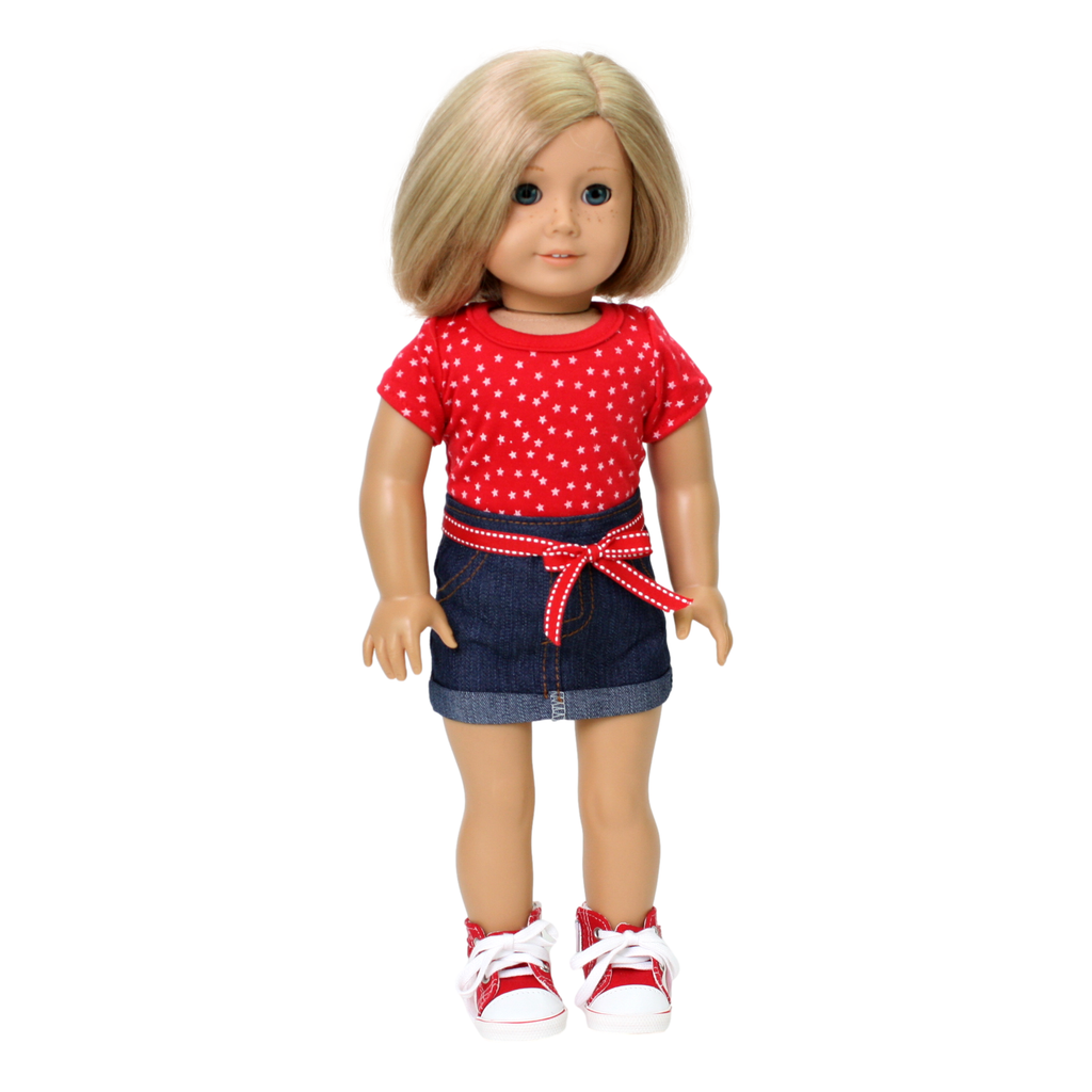 An 18-inch doll wearing a red t-shirt with a star pattern and a denim skirt with a red ribbon belt.