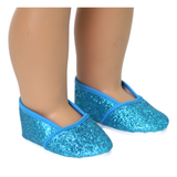 A pair of turquoise glitter slip-on shoes designed for 18-inch dolls, displayed on a doll's feet.