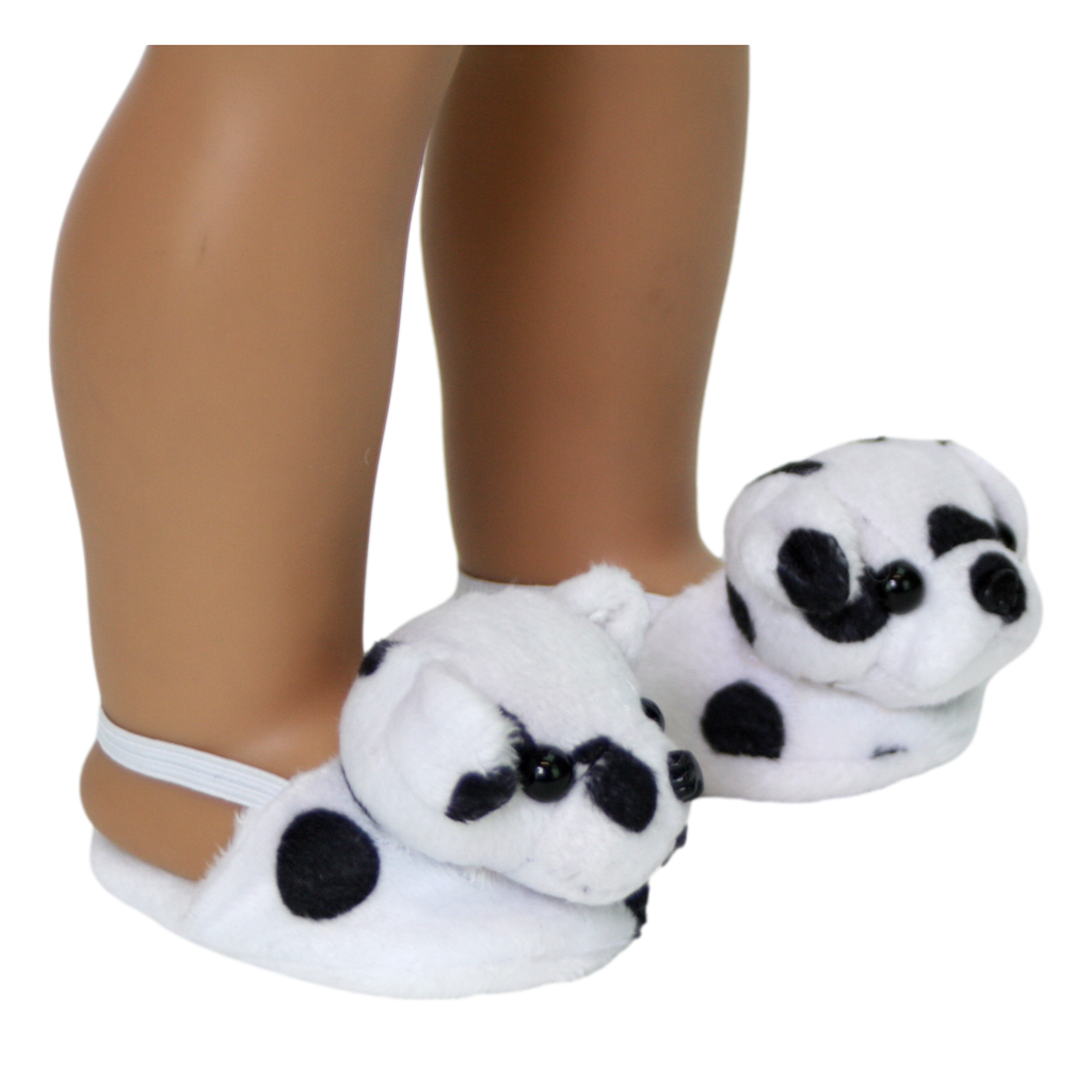A pair of white doll slippers with black spots, and the face of a Dalmatian. Designed to fit 18-inch dolls, placed on a doll's feet.