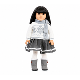 An 18-inch doll wearing a gray and white sweater and skirt set. Also wearing a gray scarf.