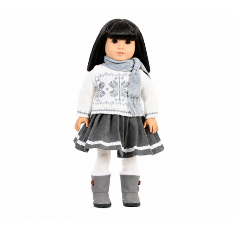 An 18-inch doll wearing a gray and white sweater and skirt set. Also wearing a gray scarf.